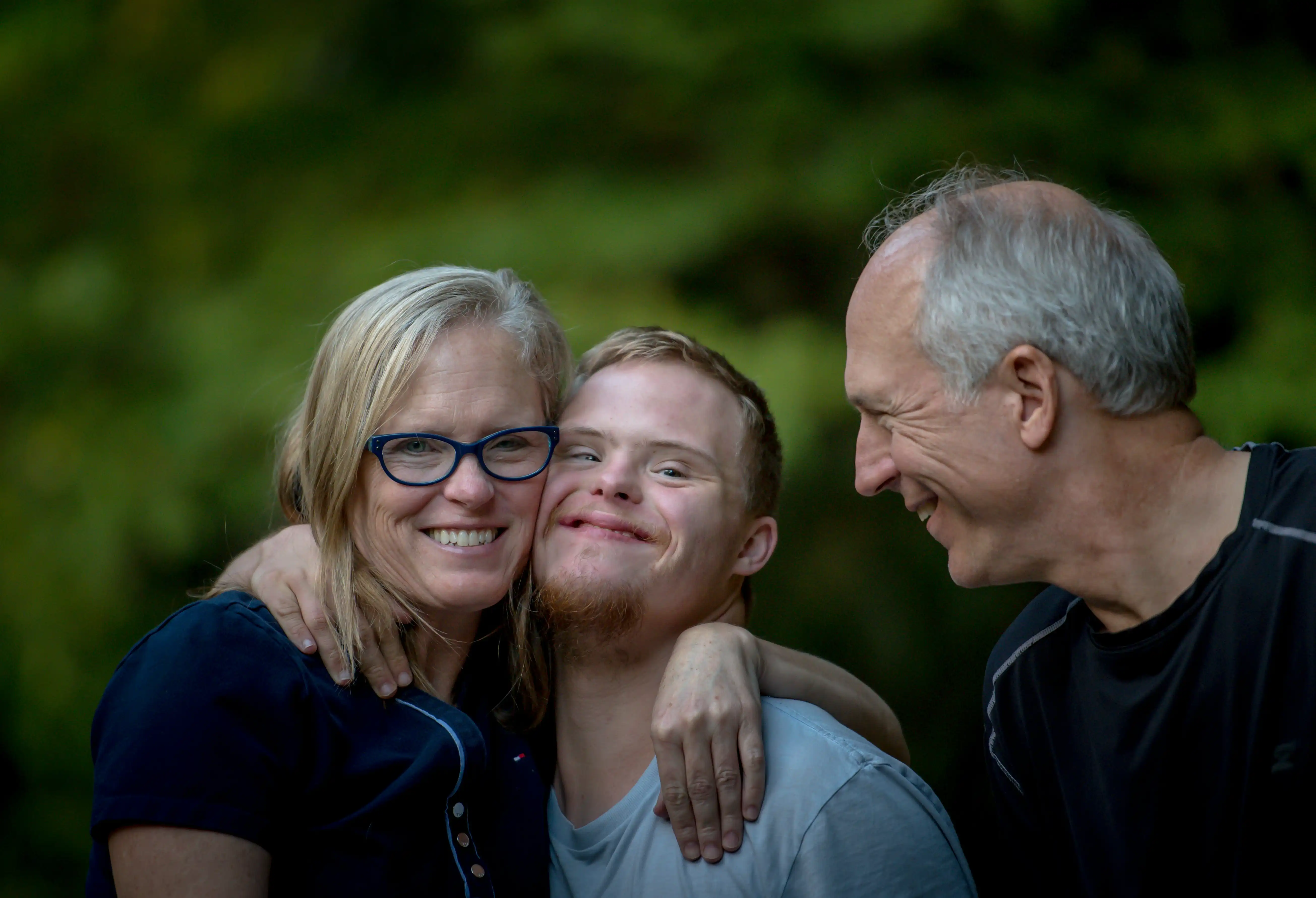 Happy multi-generational family embracing together, representing family reunification through Parents & Grandparents sponsorship