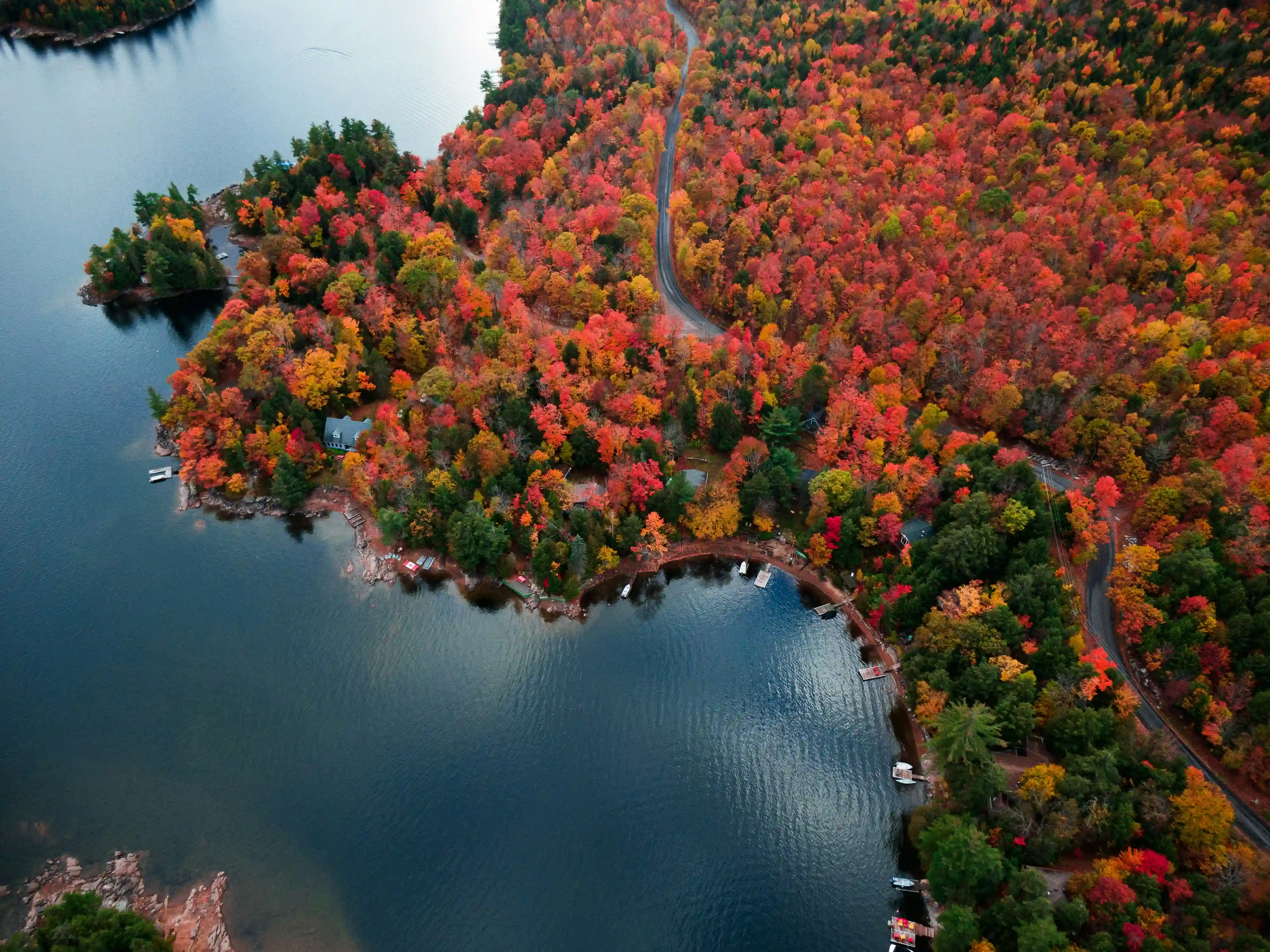 Aerial view of Canadian lake surrounded by vibrant fall foliage representing Canada's natural beauty