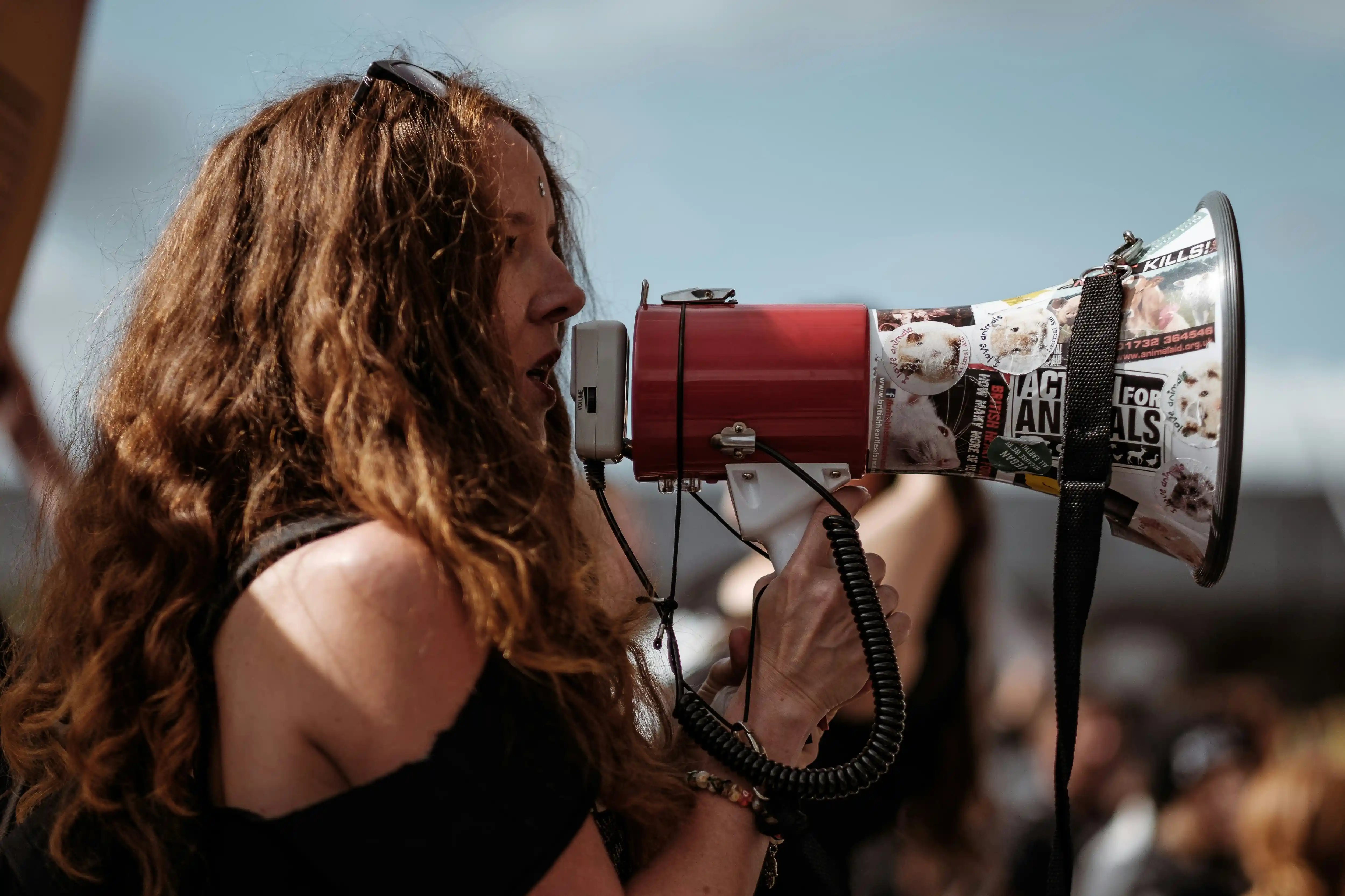 Woman advocating with megaphone representing protection and safety for refugees
